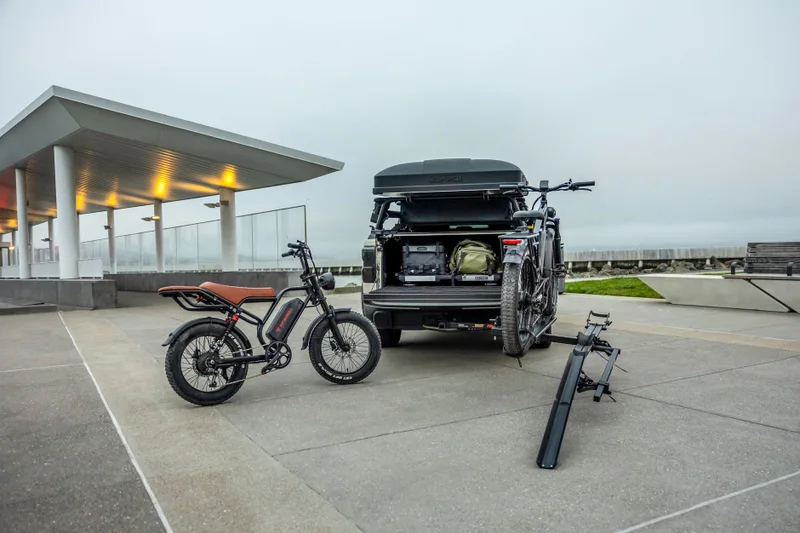 Electric bike and car packed with gear at a modern outdoor location. Perfect for travel and adventure.