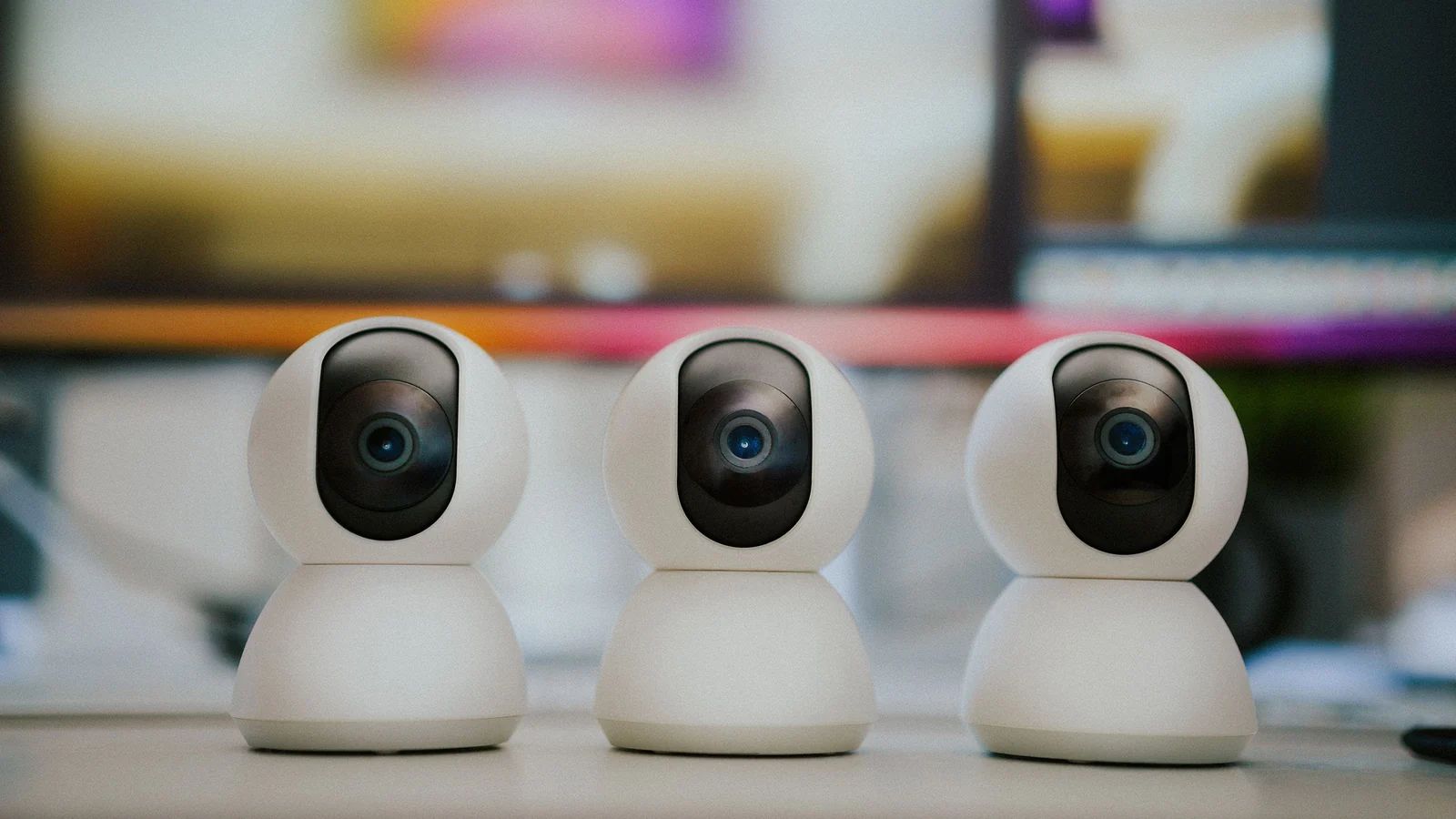 Mehrere moderne Smart-Home-Überwachungskameras auf einem Tisch in einem Innenraum